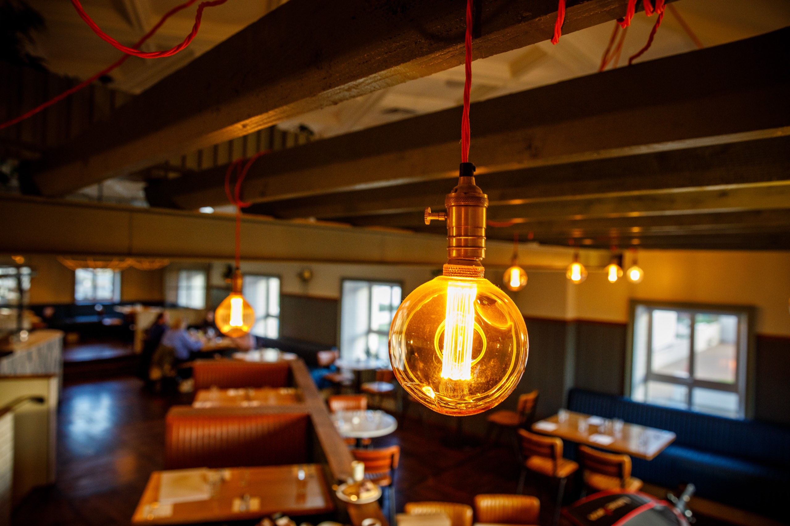 Filament bulbs glowing above the dining room at Honestly