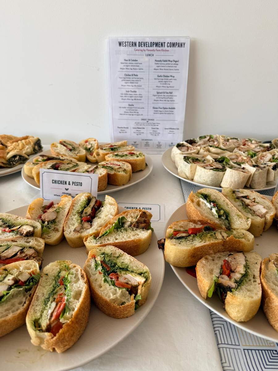 Chicken and pesto ciabatta platters with a printed lunch menu at a catered office lunch