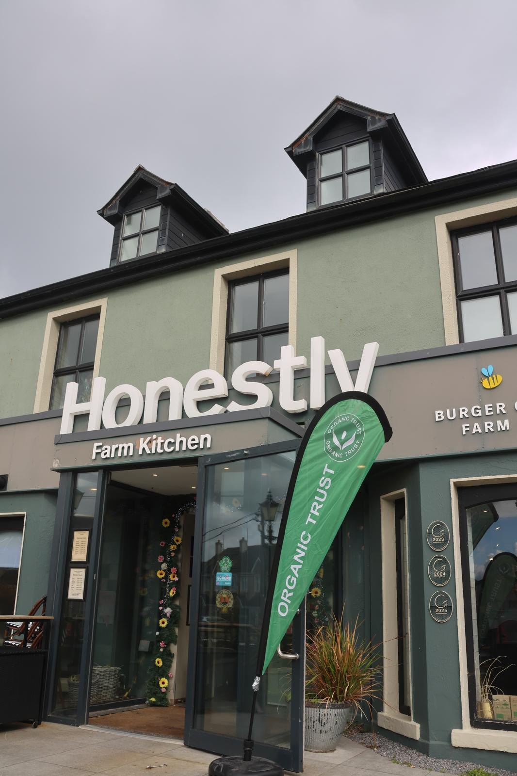 The front of Honestly Farm Kitchen, with an Organic Trust flag at the door