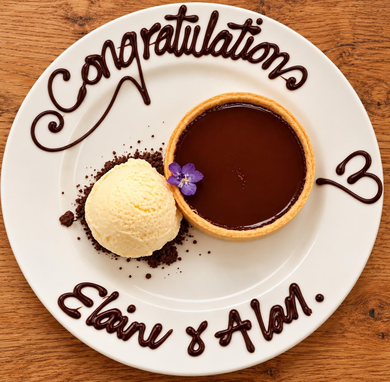 The wedding dessert: a chocolate ganache tart with ice cream, on a plate piped with 'Congratulations Elaine & Alan'